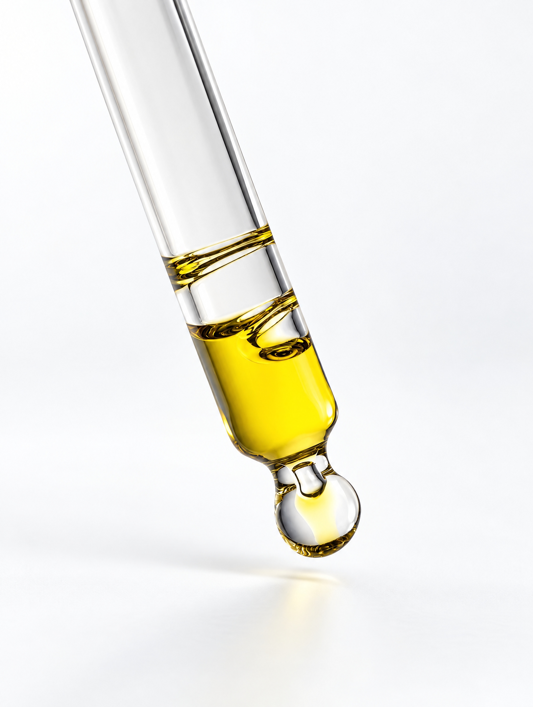 Golden serum dripping from a glass pipette